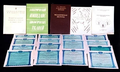 A collection of books and multiple certificates or official documents laid out on a table.