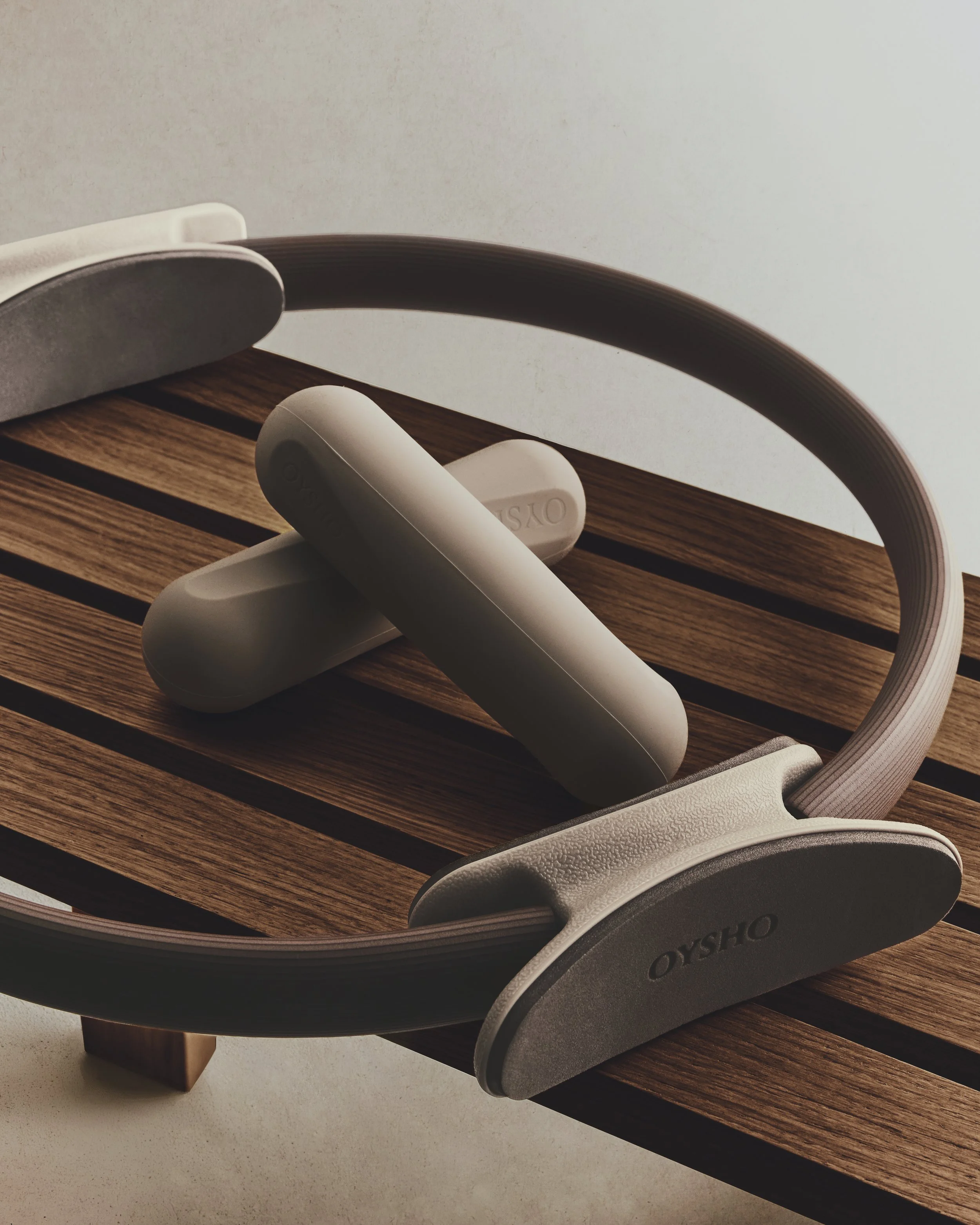 Close-up of wireless earbuds and a pair of over-ear headphones resting on a wooden surface.