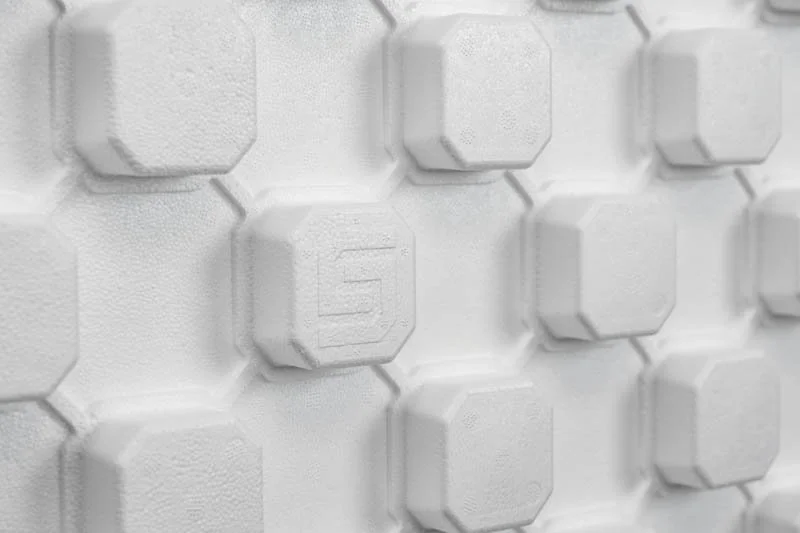 Close-up of white hexagonal texturized wall panels with embedded SuperForm 'S' icon