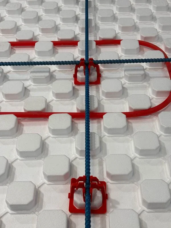 Close-up of SuperPex foam product with pipe and rebar chairs as a complete heated floor package.
