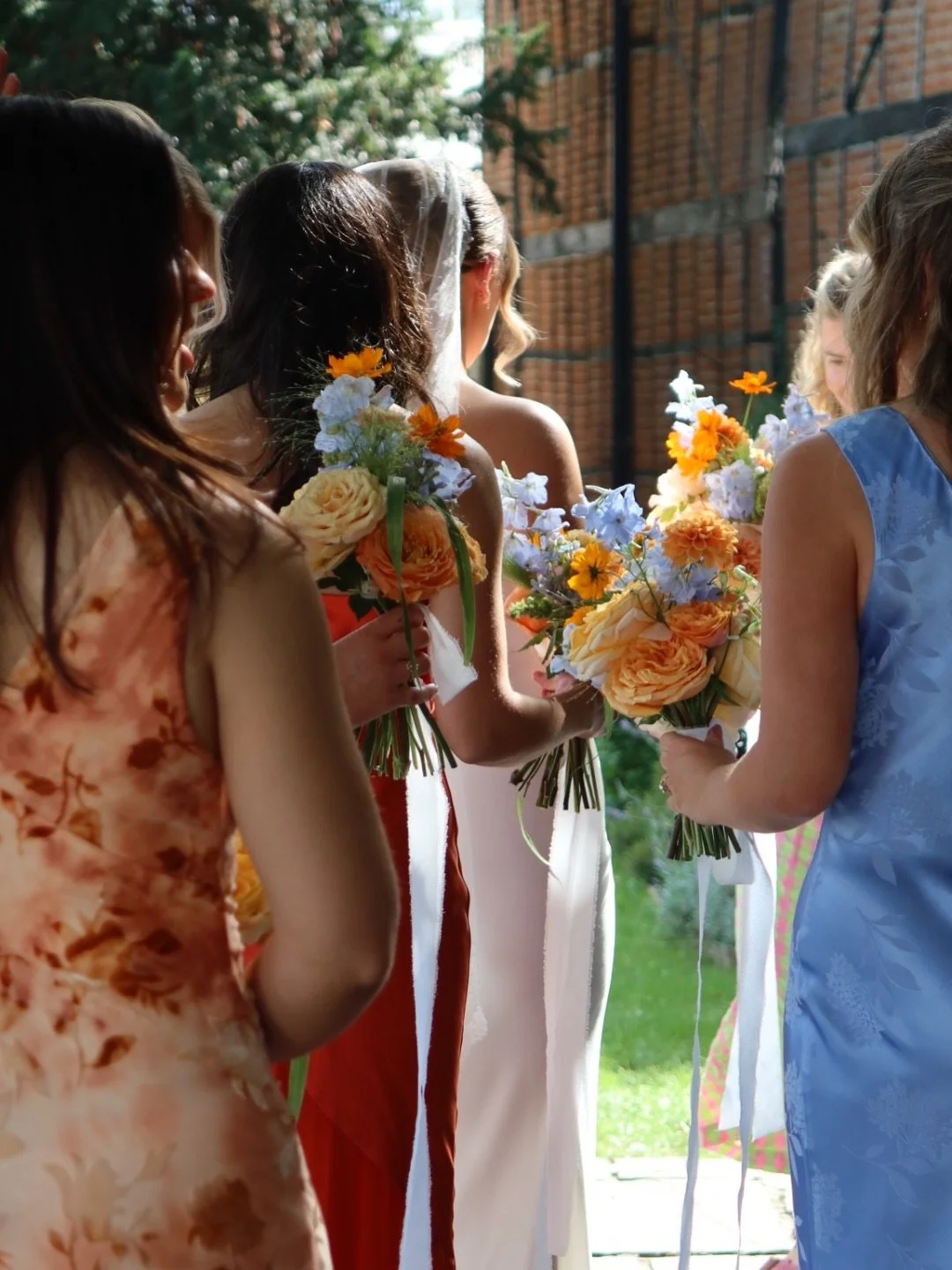 Peaches, soft blues and pops of orange, with seasonal dahlias, orange cosmos, garden roses and blue delphinium tumbling through the bouquets.

Chloe was so clear on her colour palette from the very beginning, and I loved how much personality it gave 