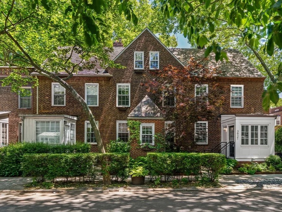 Brick Sunnyside Gardens row houses framed by mature trees and planted front gardens