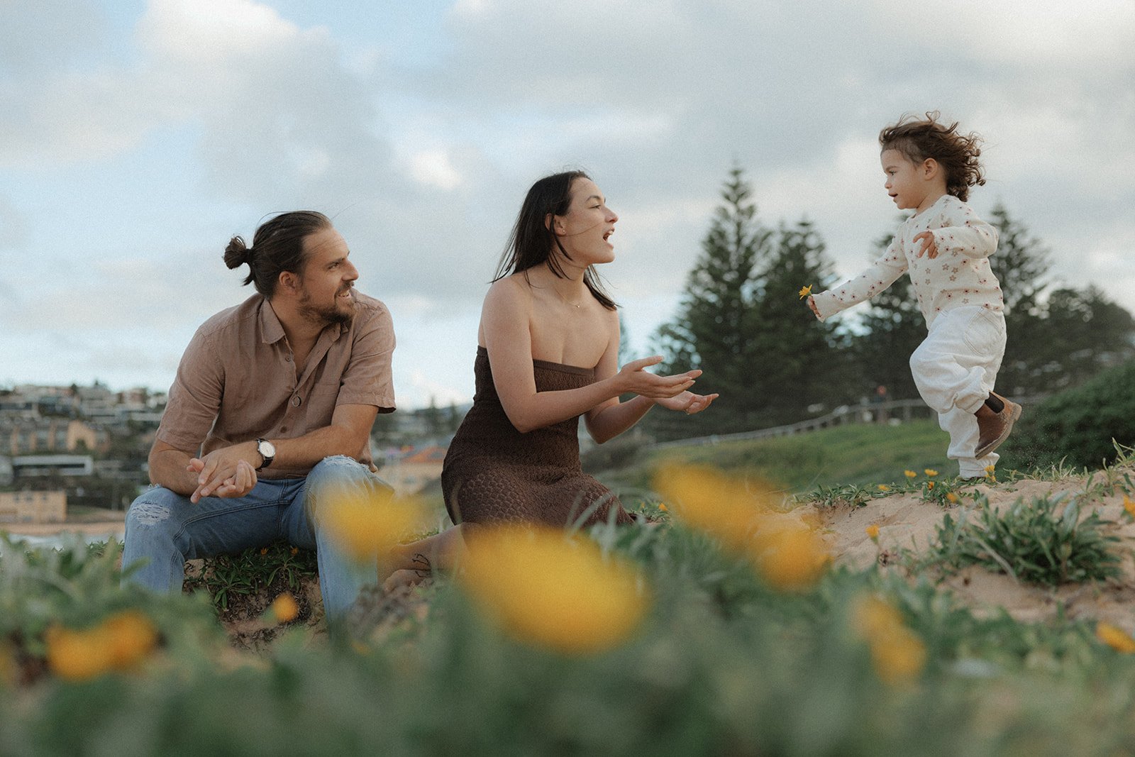 Family playing in dues picking yellow wild flowers