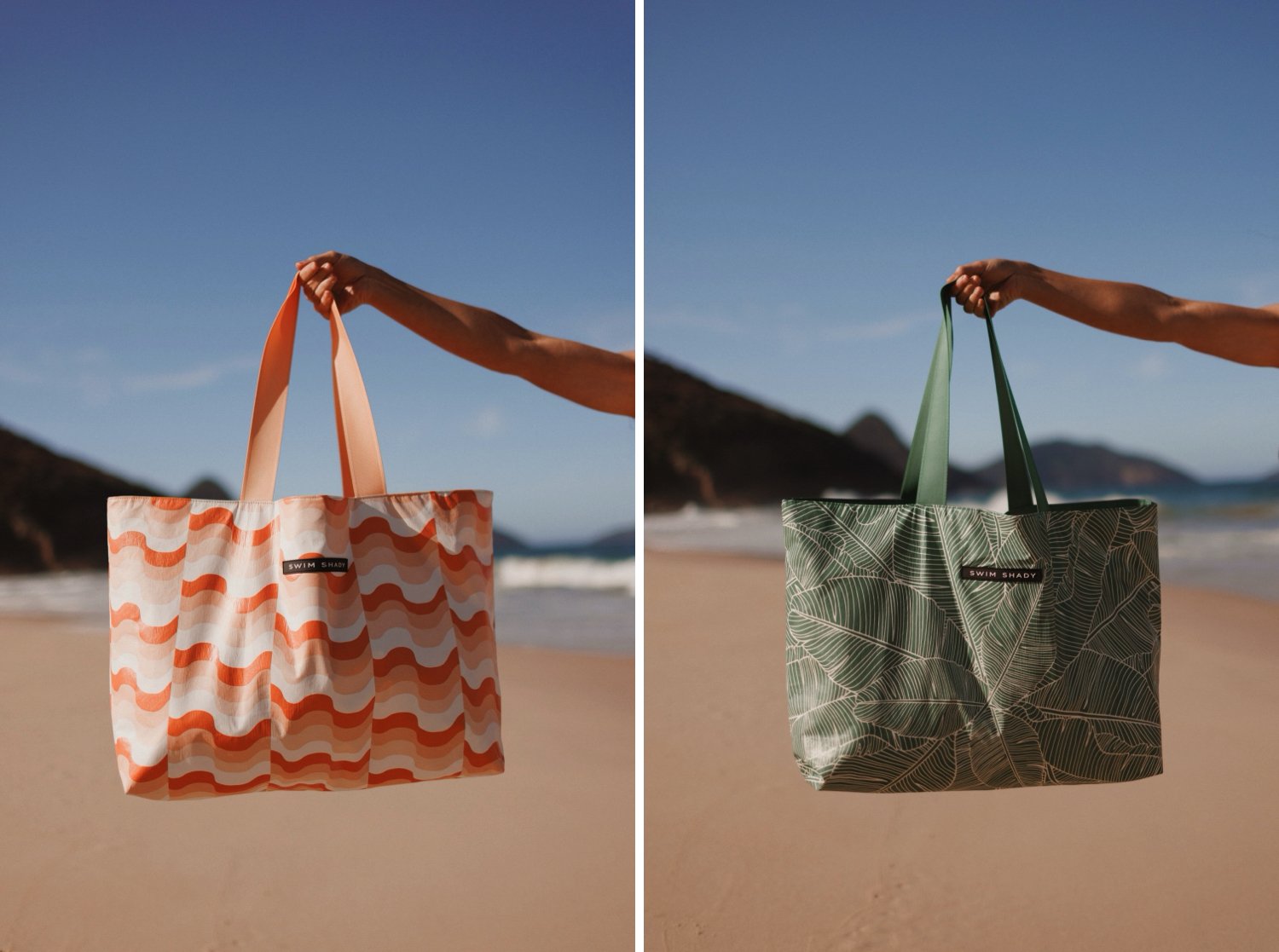 Swim Shady beach bags held against a coastal backdrop — one with orange wave print and peach straps, the other with green palm leaf print and matching straps.
