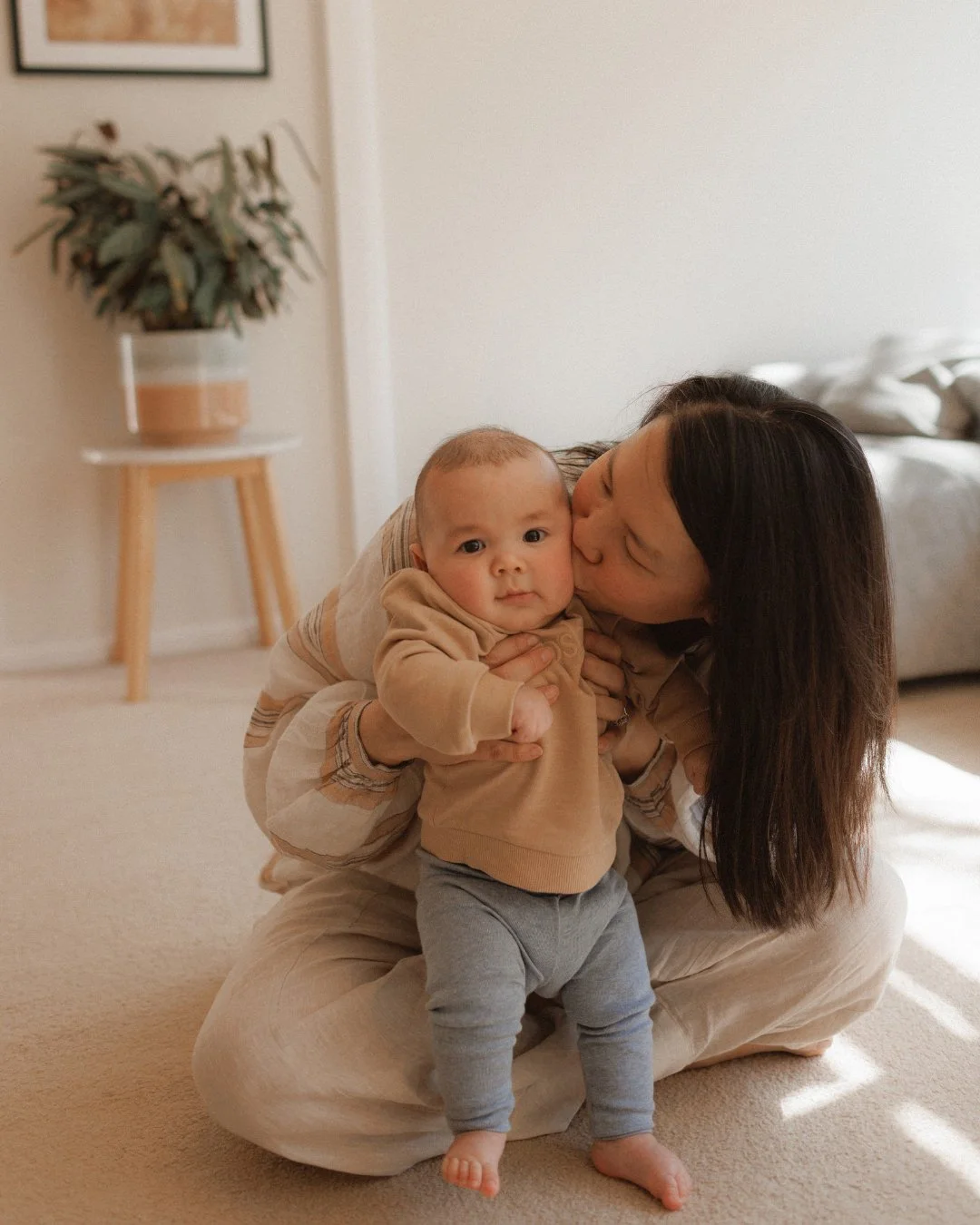 Mother with newborn baby in living room