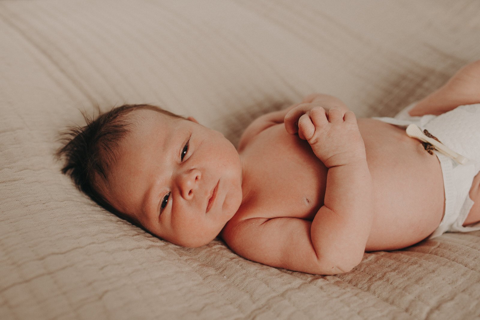 Newborn baby lying on bed