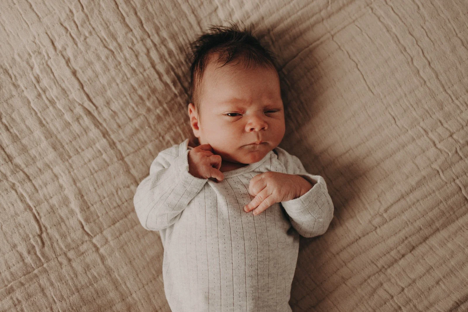 Newborn baby lying on bed