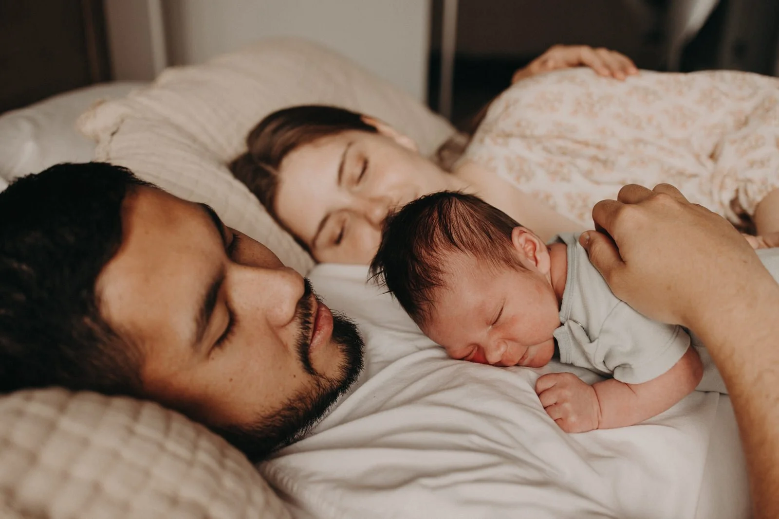 Newborn baby and parents sleeping