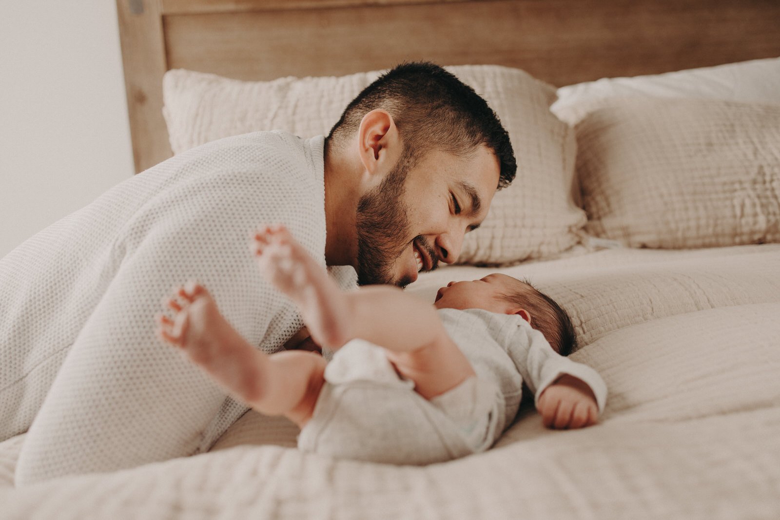 Newborn baby with father on bed