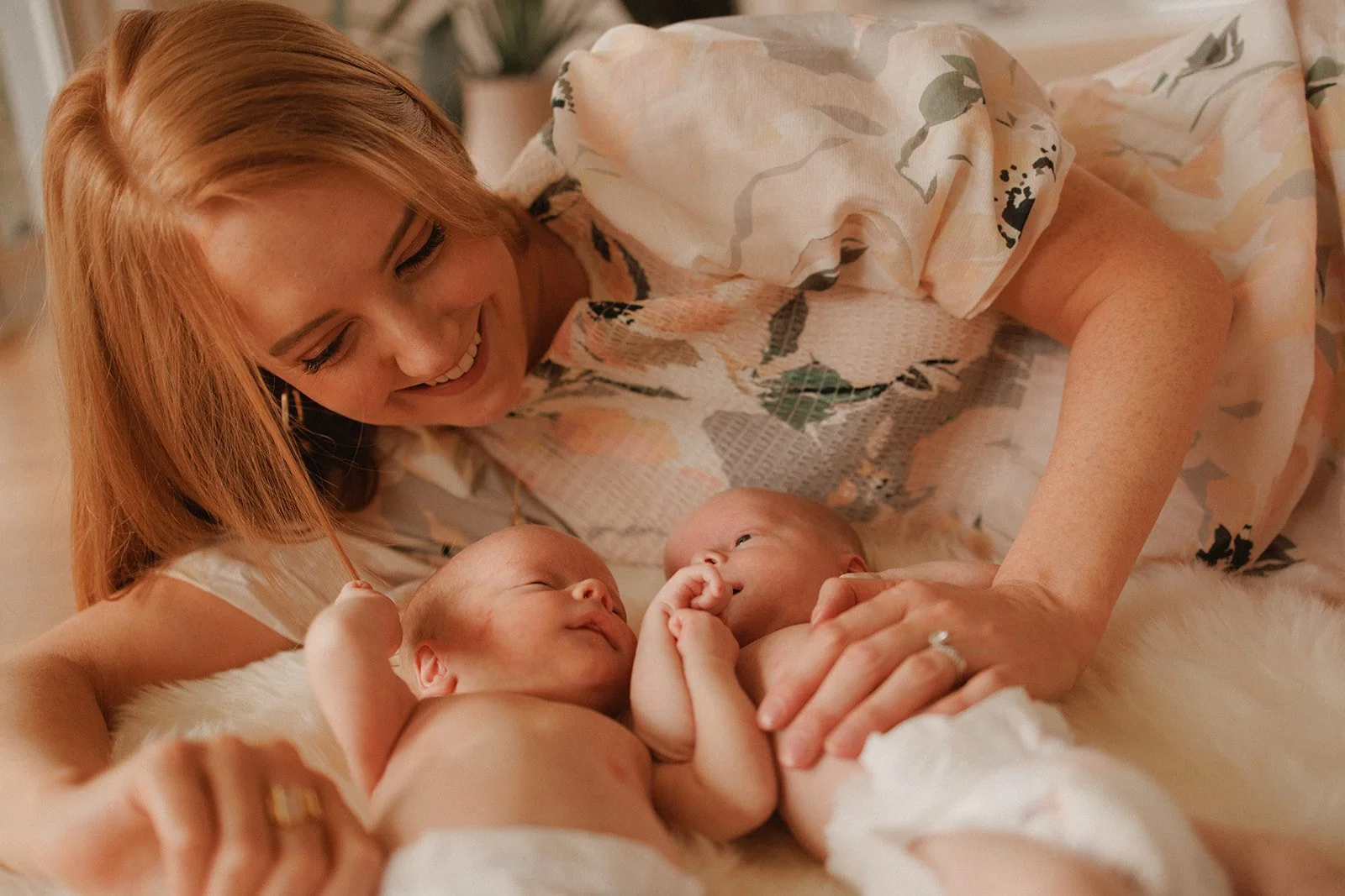 New mum with twins lying down, with blowdried hair