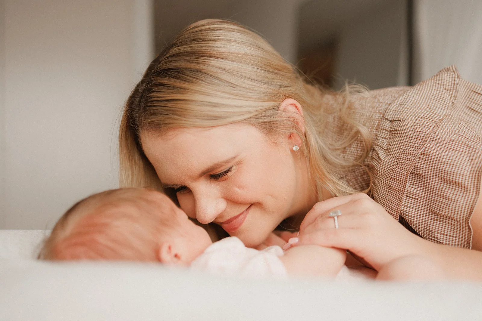 Mum cuddling newborn baby lying down