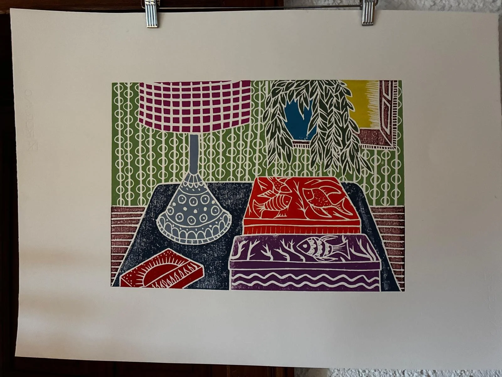 von Hand wird nun das Papier fest auf die Druckplatte gepresst und mit einem Barren die Farbe auf das Papier gedruckt