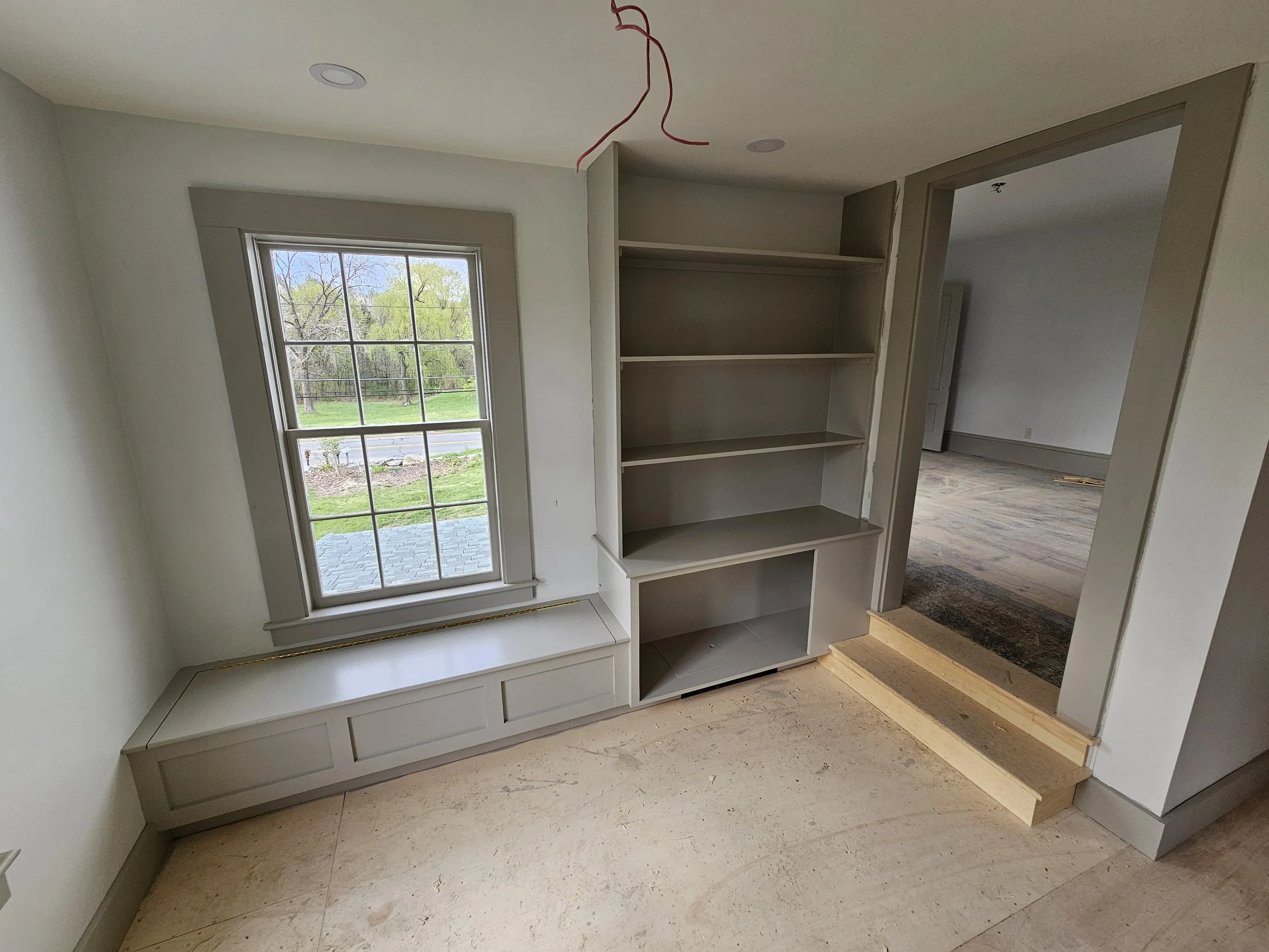 Built in storage, window trim, door casing, baseboard, and steps
