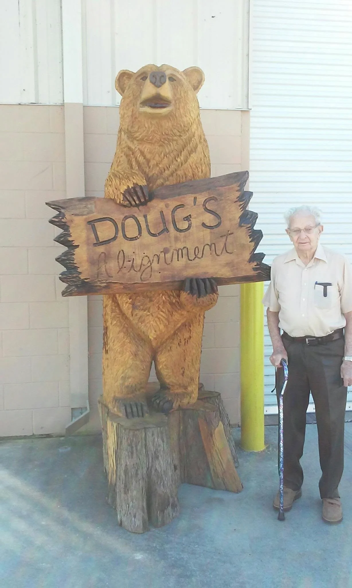 Tim’s grandfather standing beside the Doug’s Alignment carved bear sign