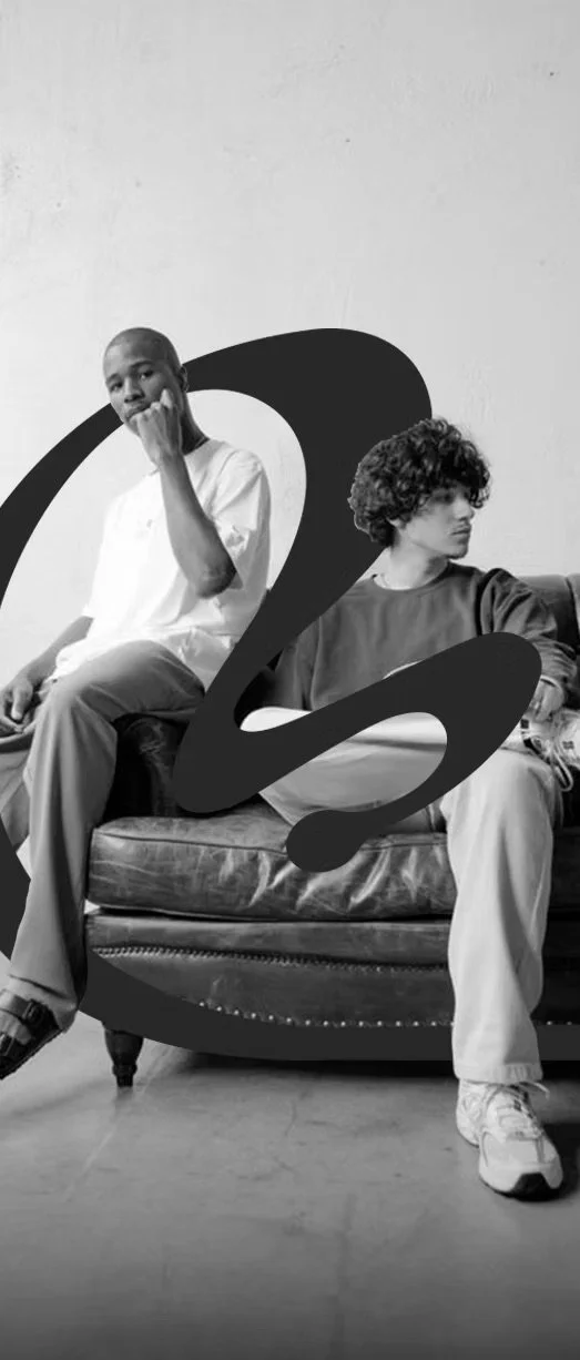 Dos jóvenes en un sillón, en una imagen en blanco y negro, con un símbolo de interrogación en medio del sillón.