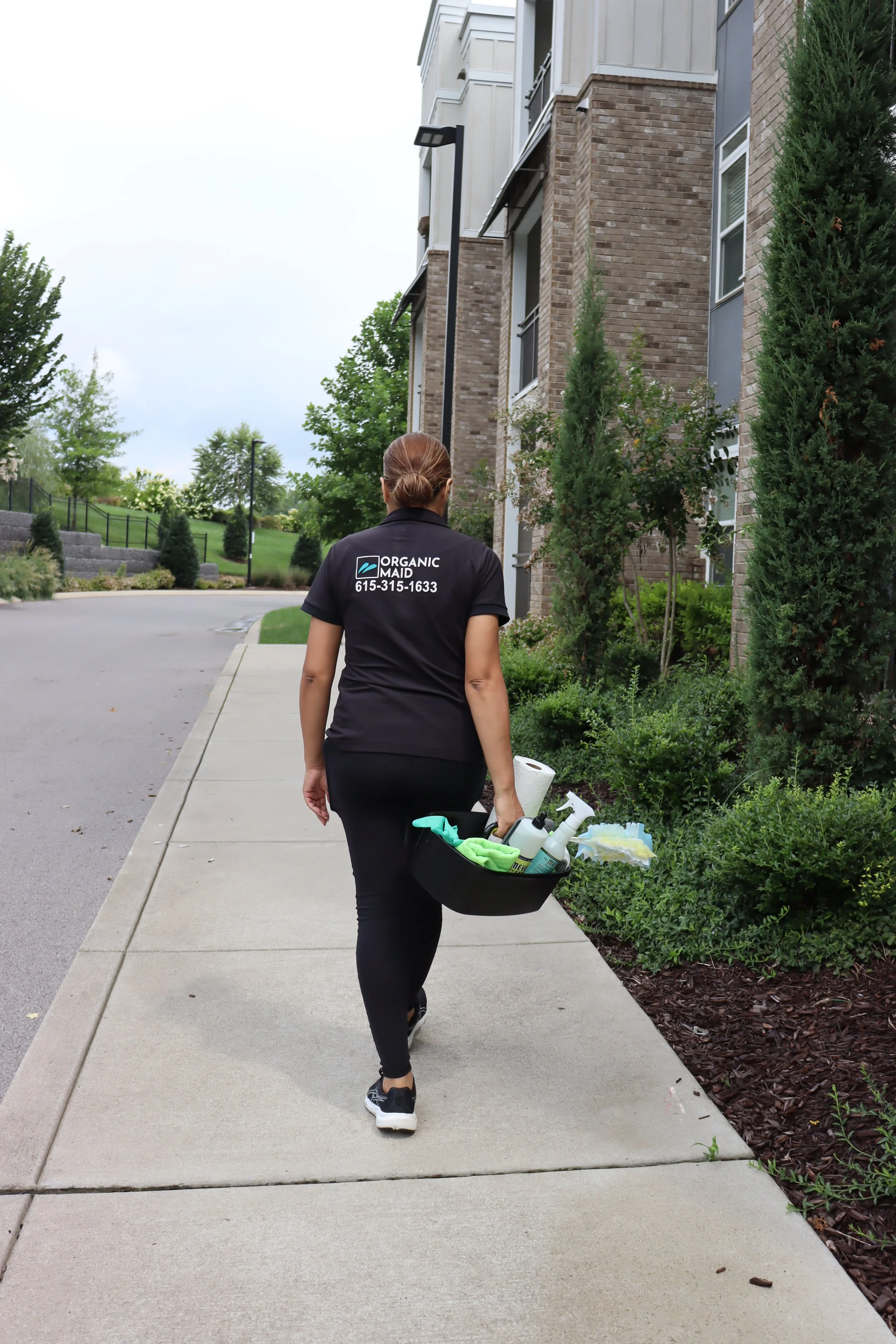 Organic Maid cleaner arriving at a client's home with professional cleaning supplies