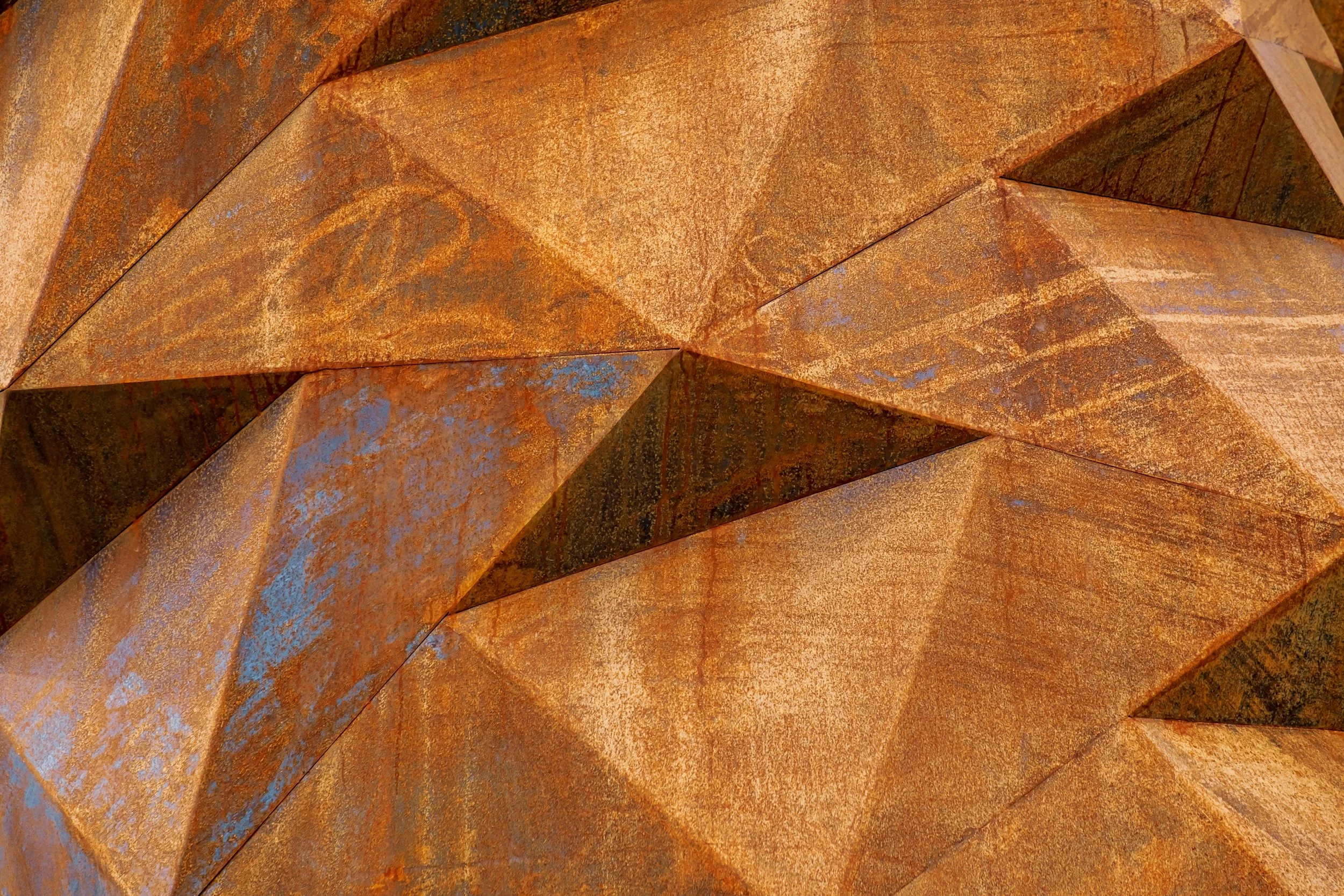 Close-up of rusted, weathered metal panels with sharp edges and a textured surface.