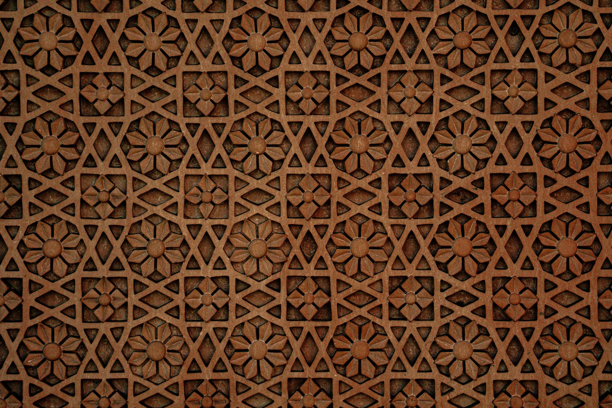 Decorative brown lattice with floral patterns and geometric cutouts.