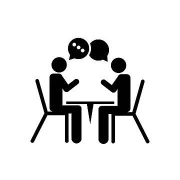 Two people sitting at a table having a conversation with speech bubbles above their heads.
