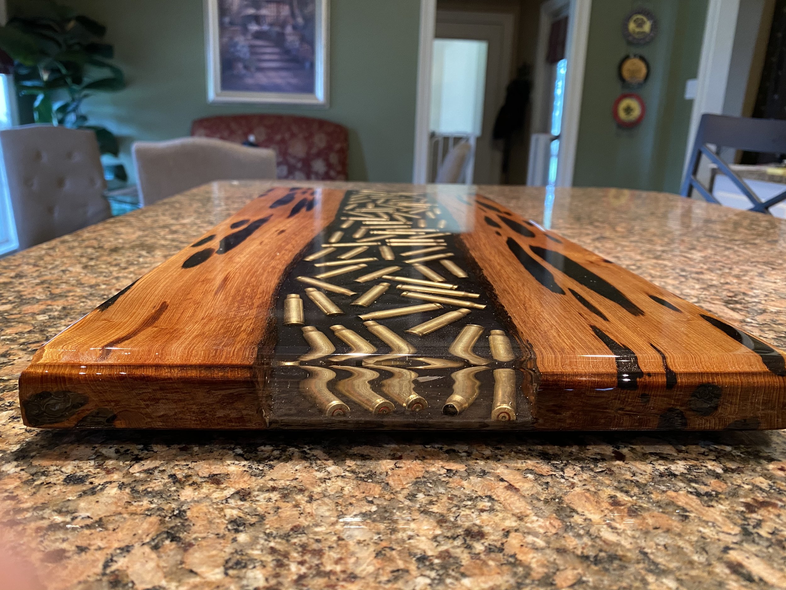 pecky cypress chacuterie board with clear epoxy containing bullets