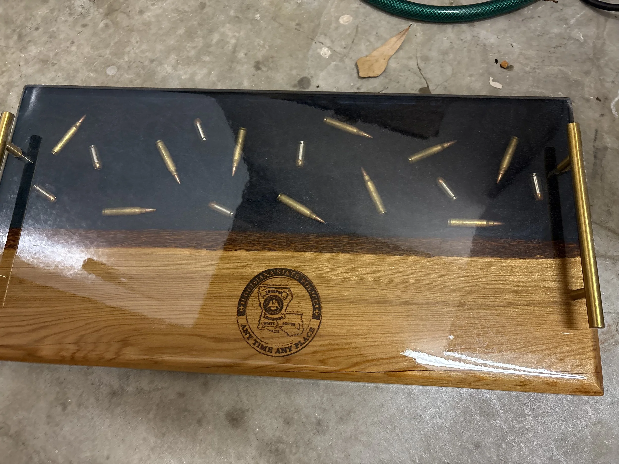 custom cypress chacuterie board with clear epoxy containing bullets