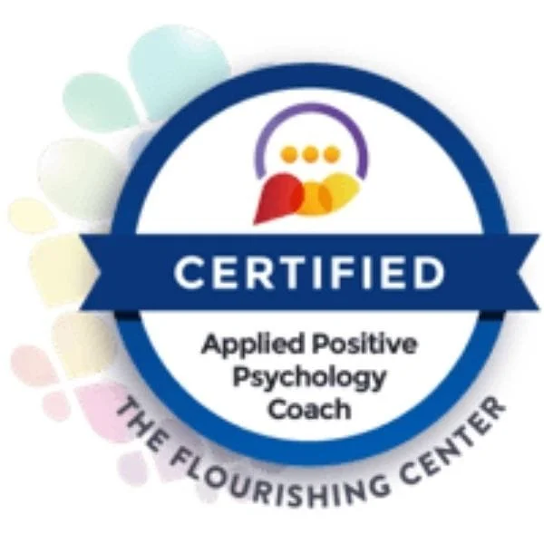 A certification badge for Applied Positive Psychology Coach from The Flourishing Center, featuring a colorful logo and blue ribbon.