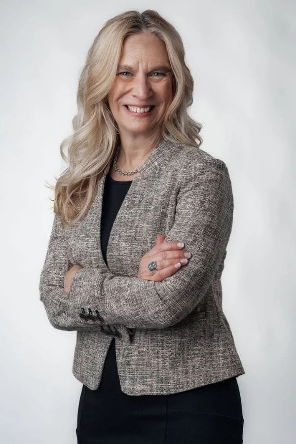 Executive coach Pari Smith, wearing a gray blazer, standing with arms crossed.
