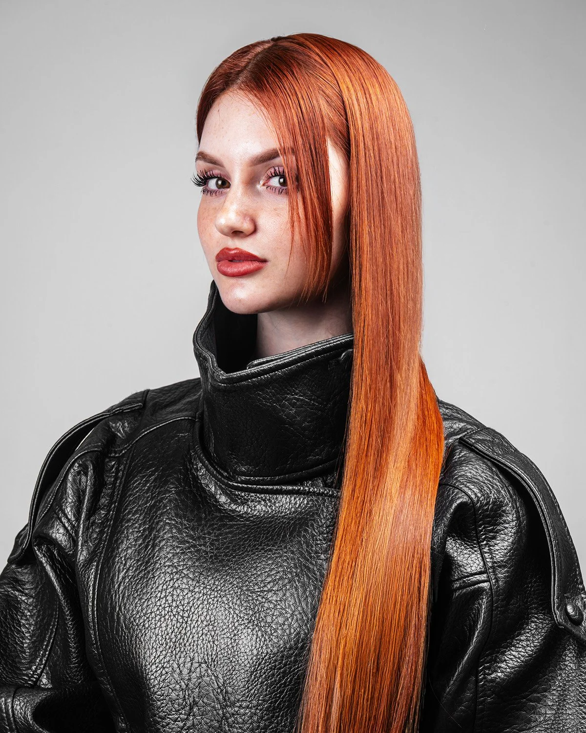 Ragazza con capelli lunghi e rossi, indossa una giacca in pelle nera