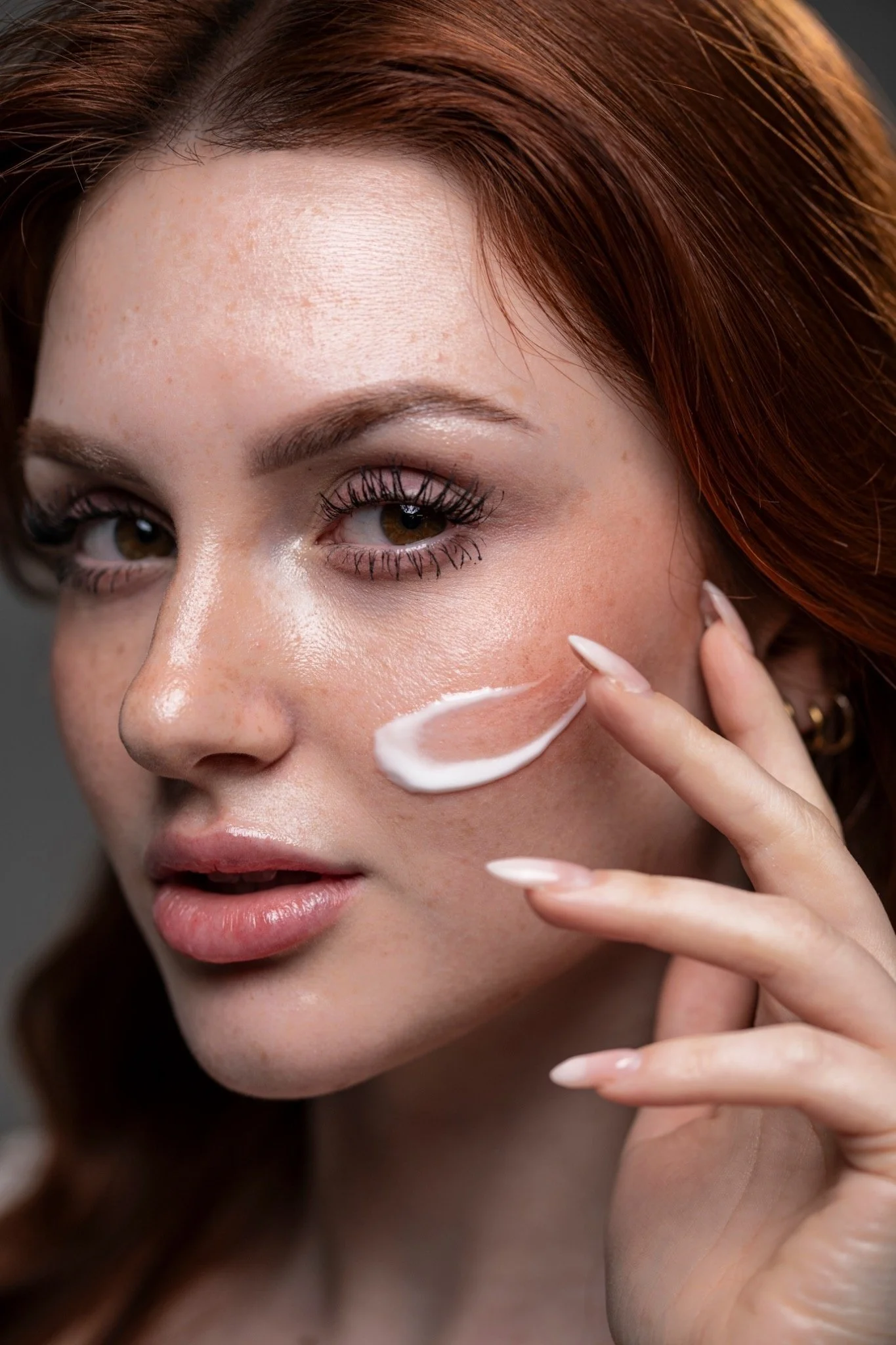 Asia Zeggio applica una crema viso durante uno shooting skincare e beauty.