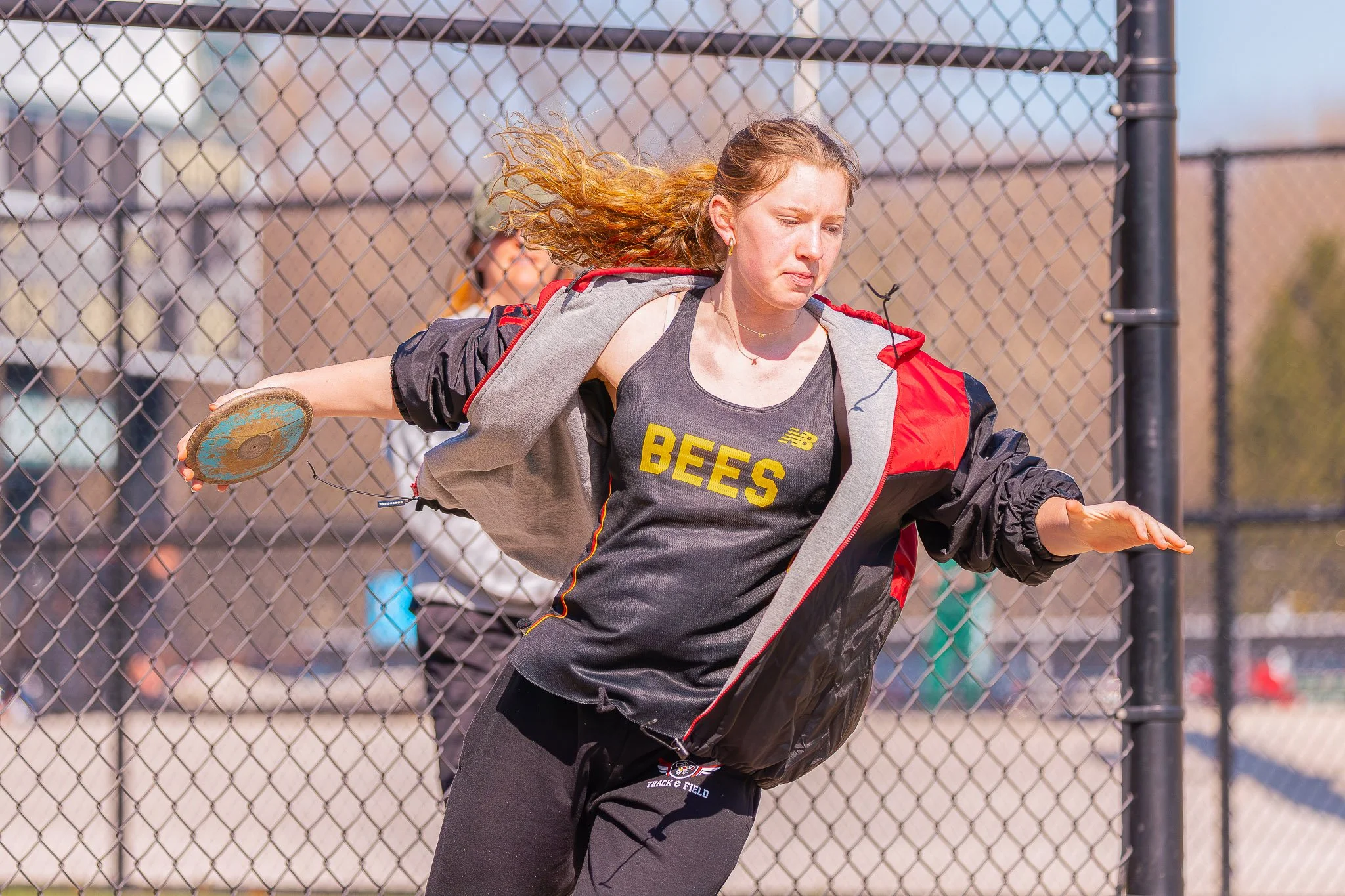A woman with red hair preparing to throw a discuss in a fielding event.