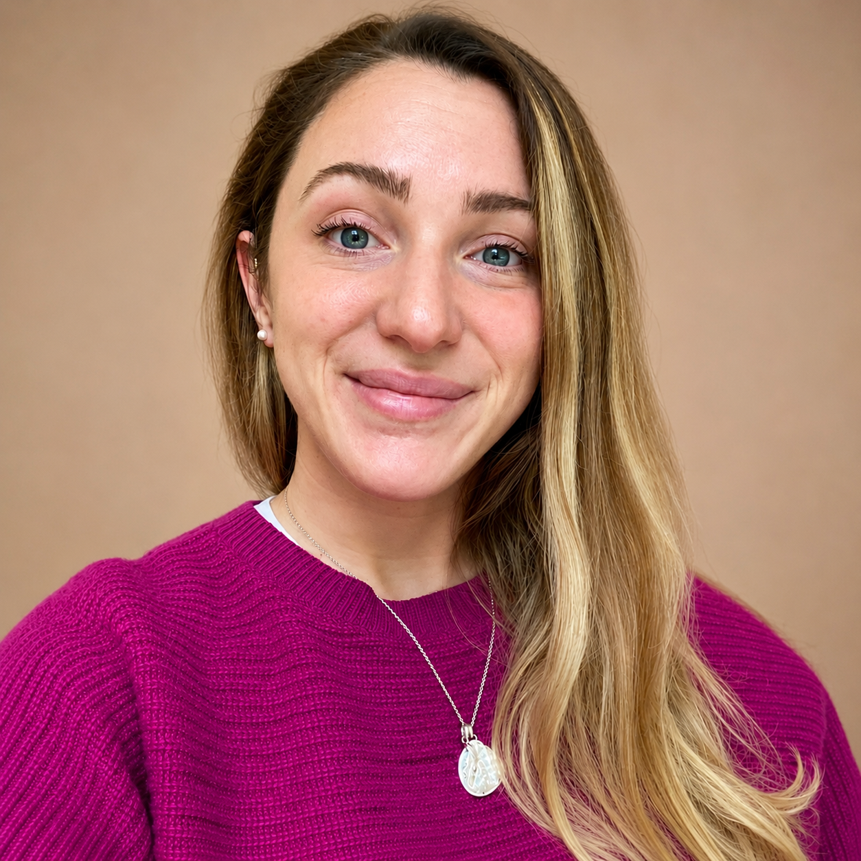 A Senior Brand Copywriter with a long wavy blonde hair and a fuchsia cashmere jumper