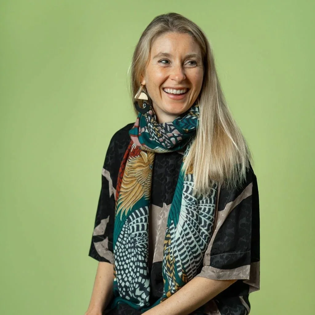 Headshot of smiling female tutor with short blonde hair wearing a lanyard.