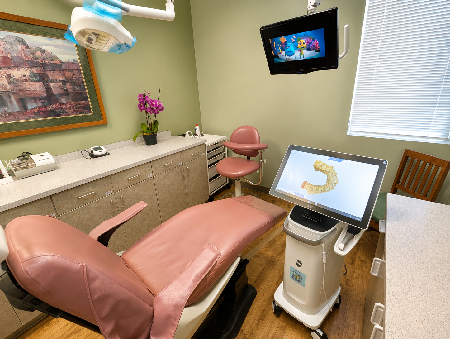 A dental treatment room with a pink dental chair, a patient monitor displaying a dental impression, a TV screen showing animated characters, a counter with dental tools, a potted orchid plant, and a window with closed blinds.