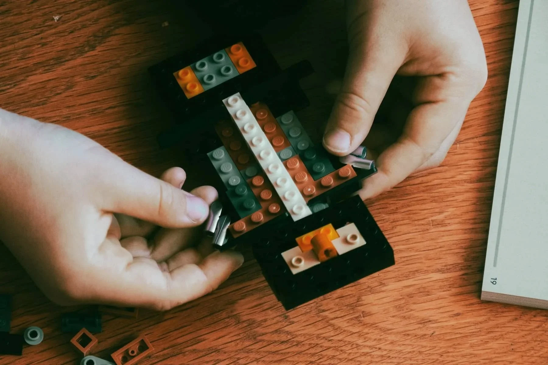 Two hands using LEGO bricks during creative play, representing child-centred therapy