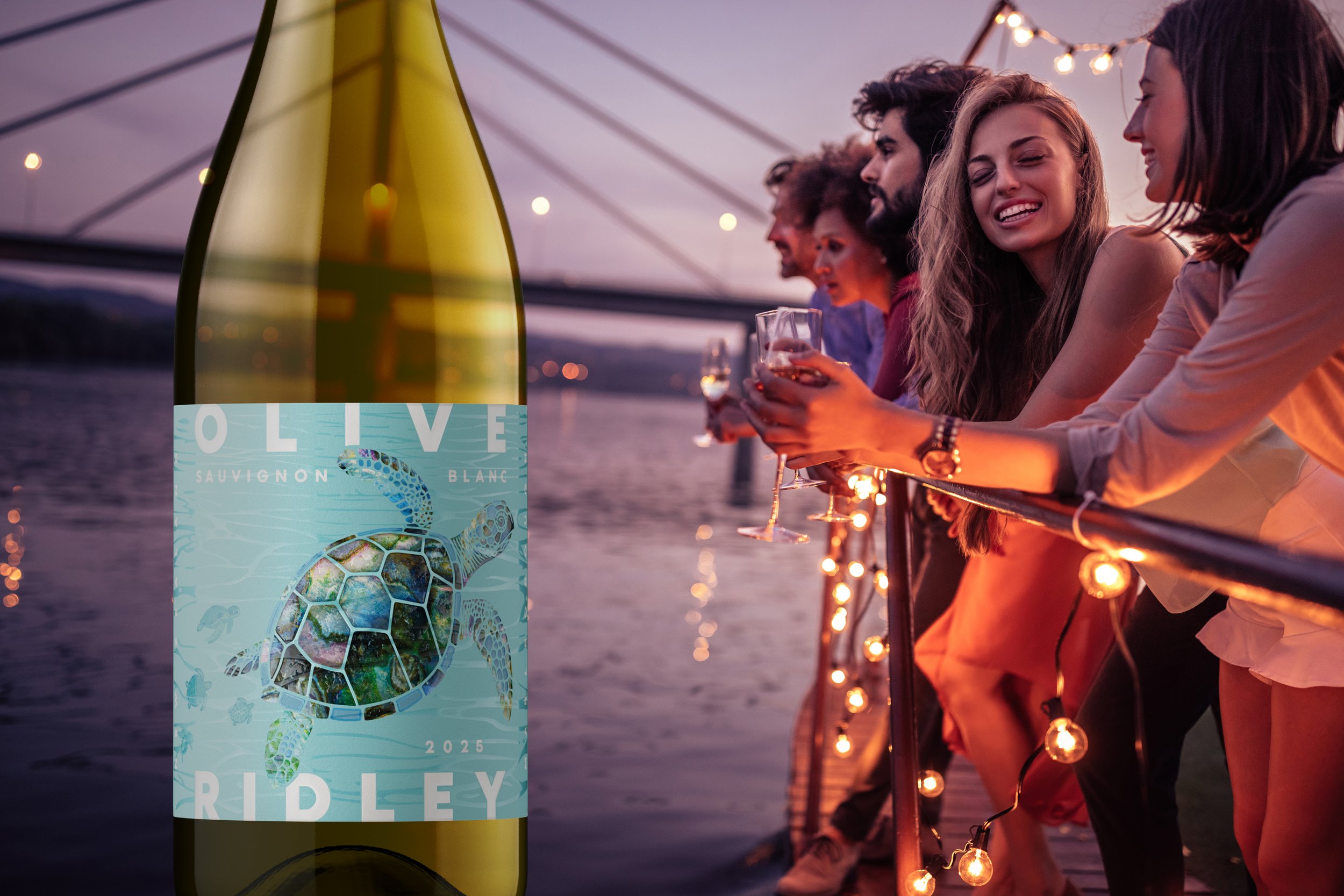 A group of friends enjoying drinks on a bridge overlooking a body of water during sunset, with string lights and a bottle of wine in the foreground.