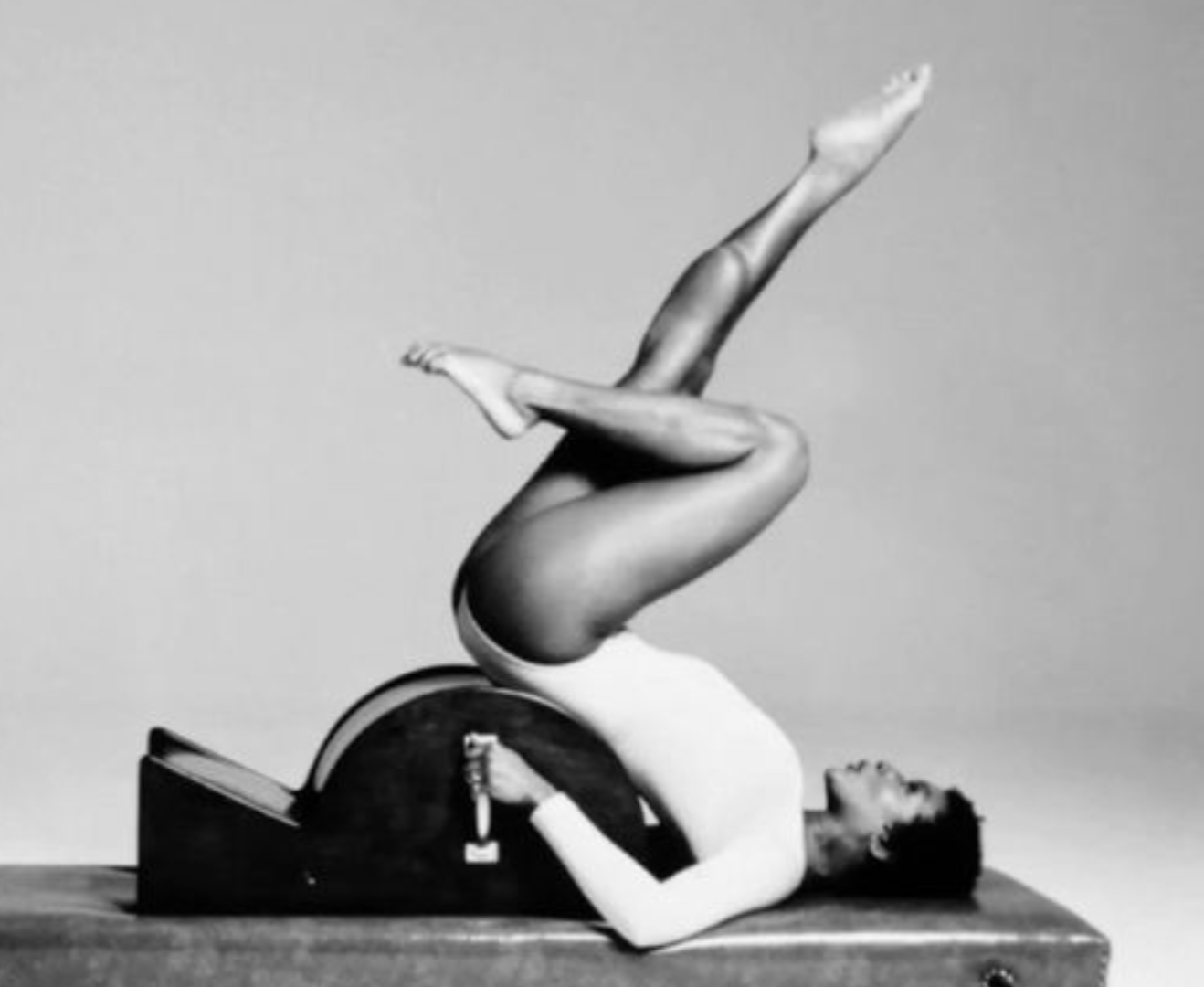A woman on a Spine Corrector Pilates apparatus.
