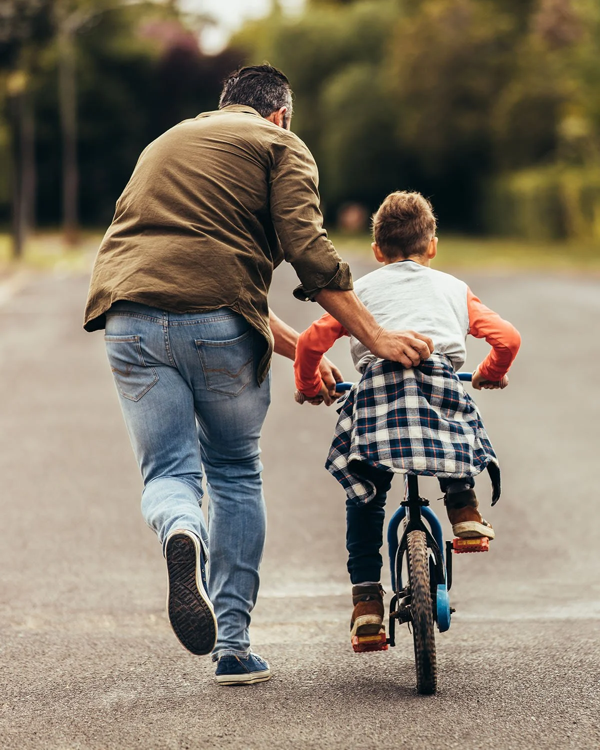 Father teaching son to ride a bike