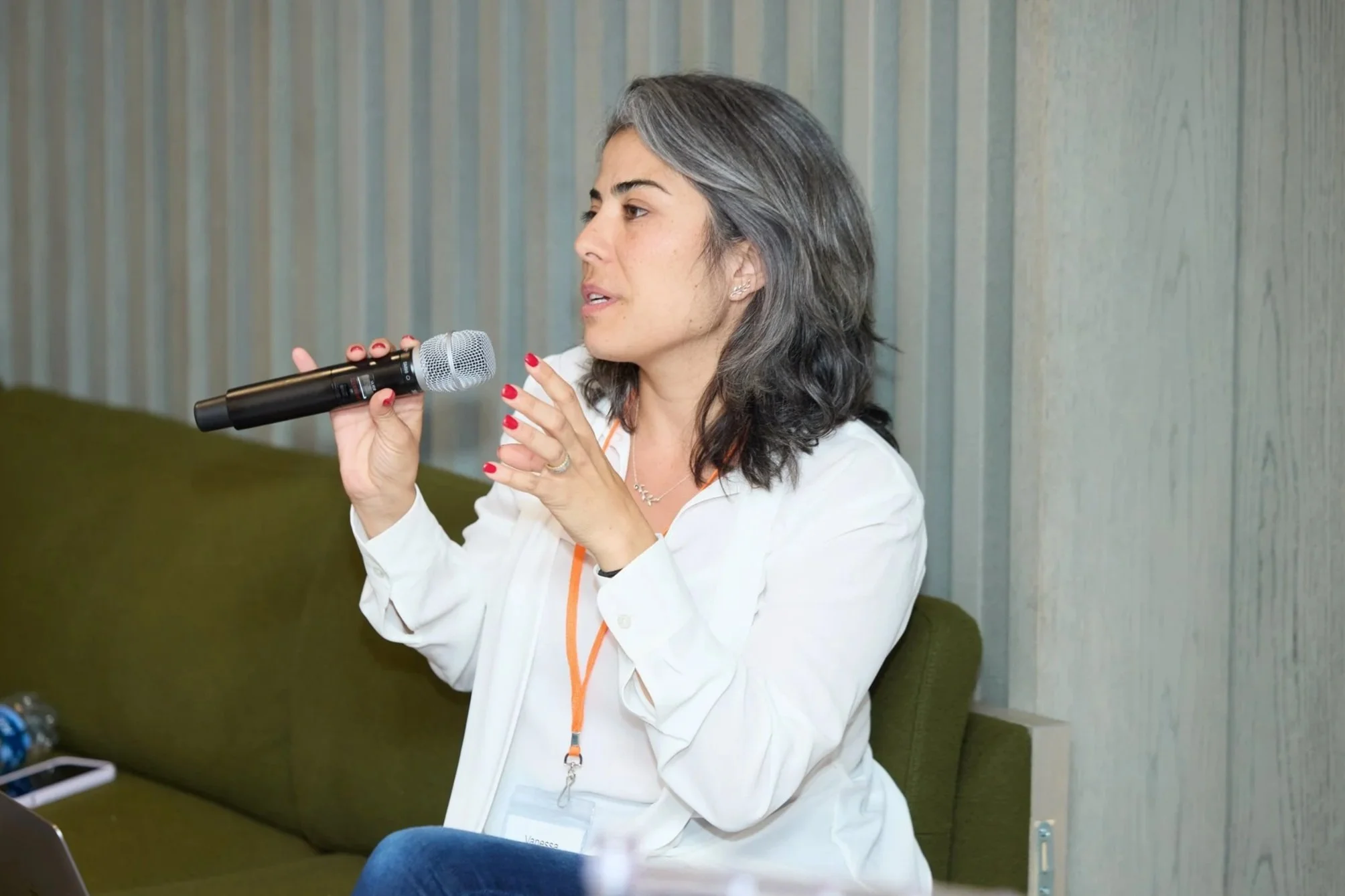 InPulso Founder, Vanessa Montalban Hammett, holding a microphone speaking at a conference