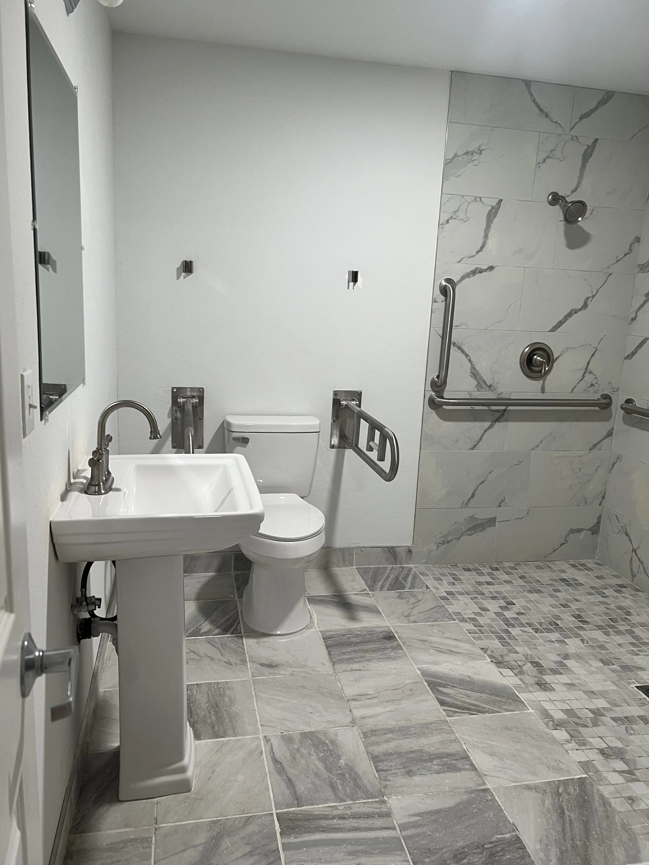 Resident-friendly bathroom at Neighbors AFH Inc in Tacoma, designed for safety and comfort with grab bars and marble finishes.