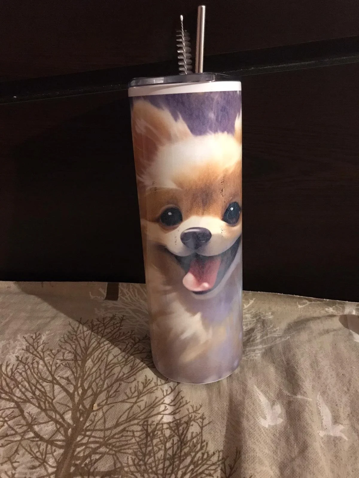 Travel tumbler with a smiling dog face, straw, and cleaning brush.
