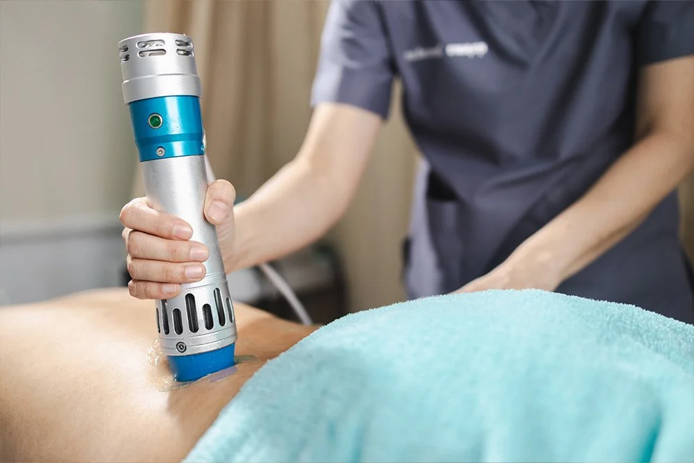 A medical professional is performing ultrasound therapy on a patient's back in a clinic.