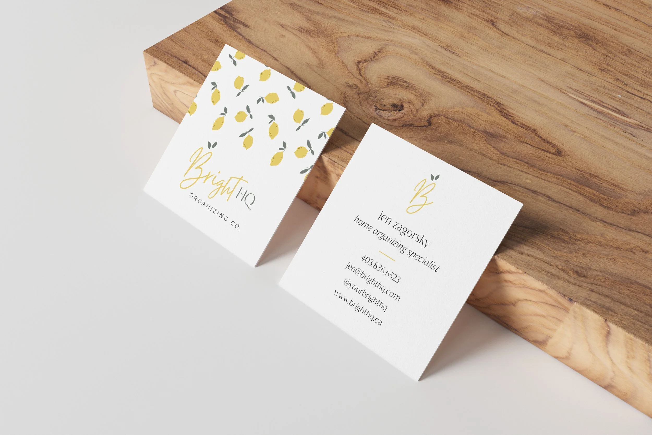 Two business cards on a wooden surface; the left card features a lemon pattern and reads "Bright HQ Organizing Co.," while the right card lists contact details for "jen zagorsky, home organizing specialist."