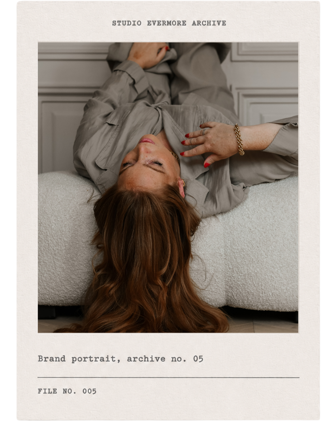 A woman with red hair lying on a bed with gray bedding, wearing a gray shirt, with her eyes closed and hand resting on her chest, surrounded by a frame labeled 'Studio Evermore Archive' and notes indicating a brand portrait for archive number 05.