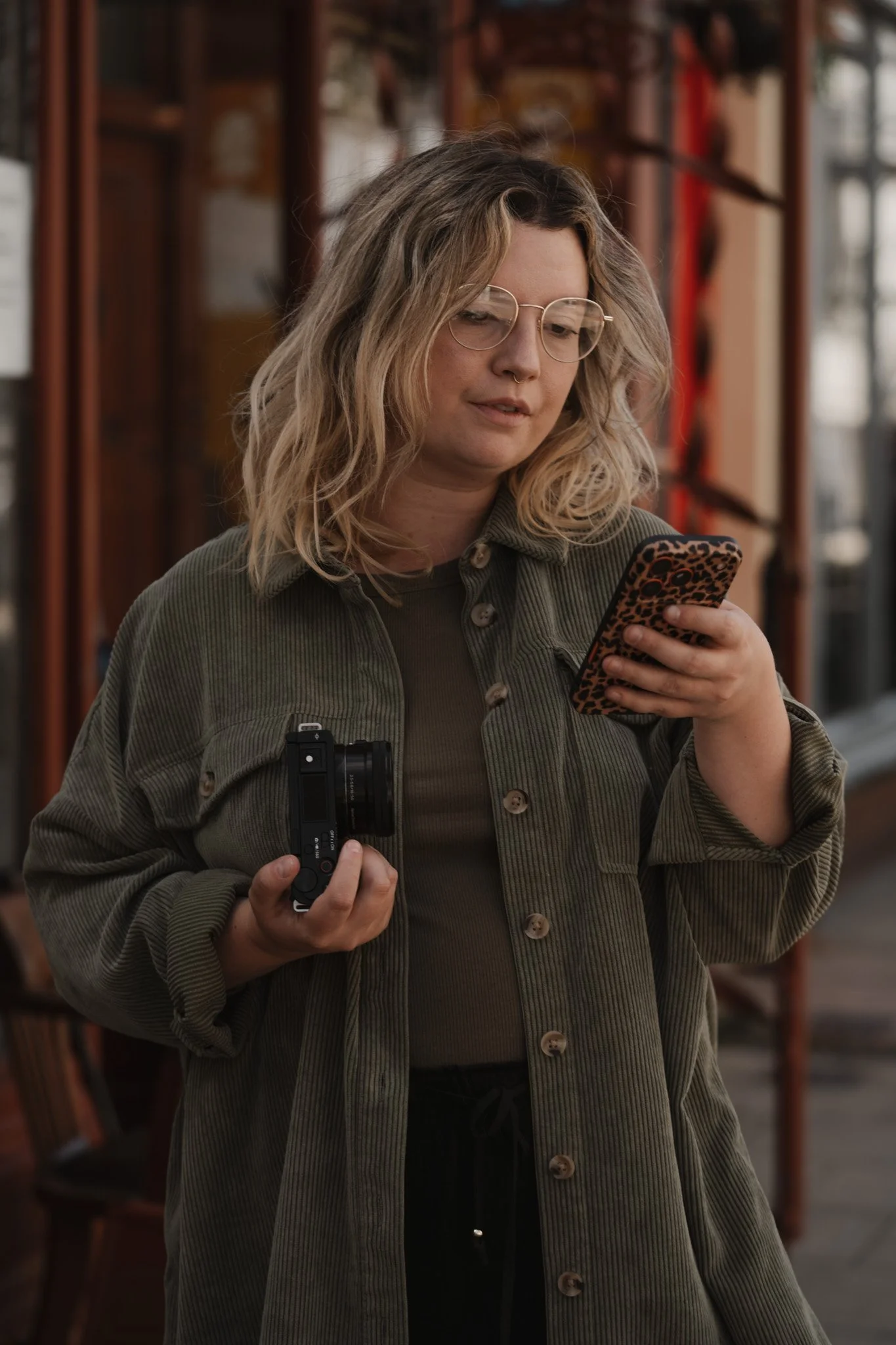 Branding shoot for a social media manager and content creator holding a camera and phone in Southsea.