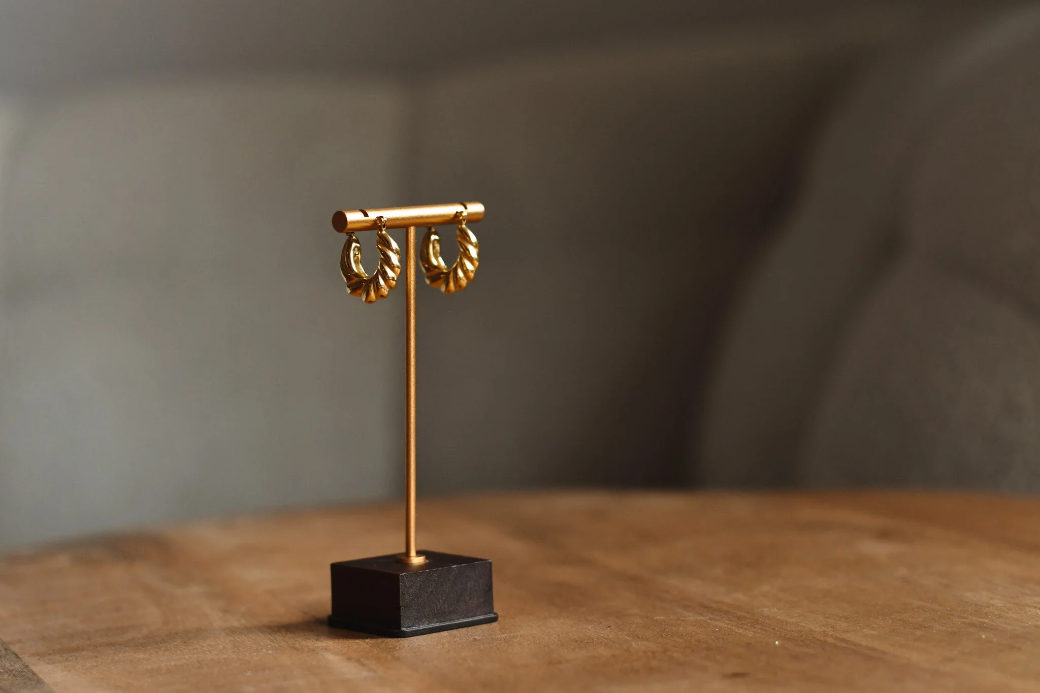 Remote product photography for a jewellery brand, featuring gold earrings styled on a display stand.