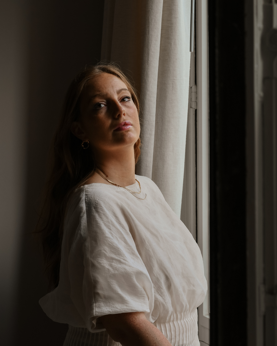 Modelled product photography for a luxury jewellery brand, featuring a model in a lifestyle setting wearing gold jewellery.