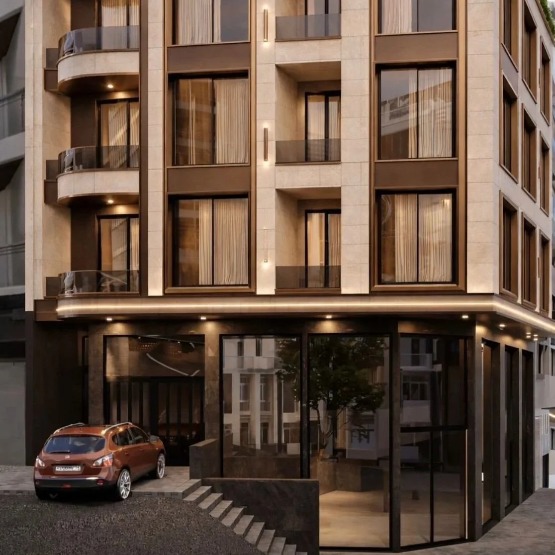 Modern multi-story building with balconies, large glass windows, and a storefront entrance at street level.