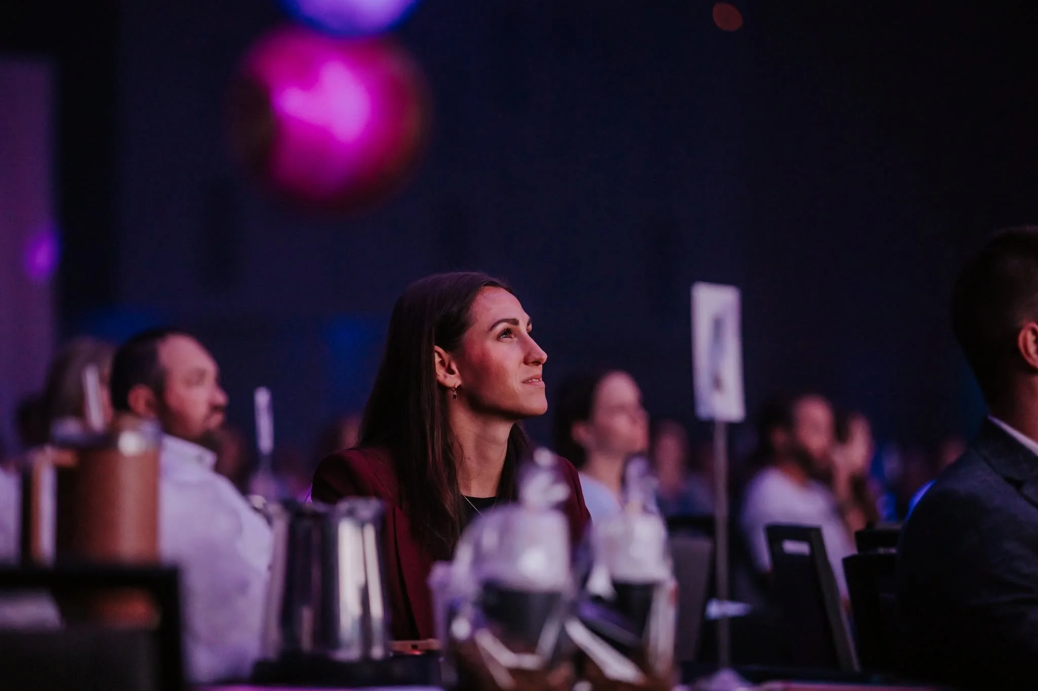Woman looking at speaker on stage.