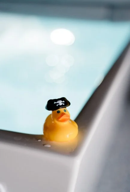 A rubber ducky water thermometer on the edge of the cold plunge tub at Culture Cove retreat space.