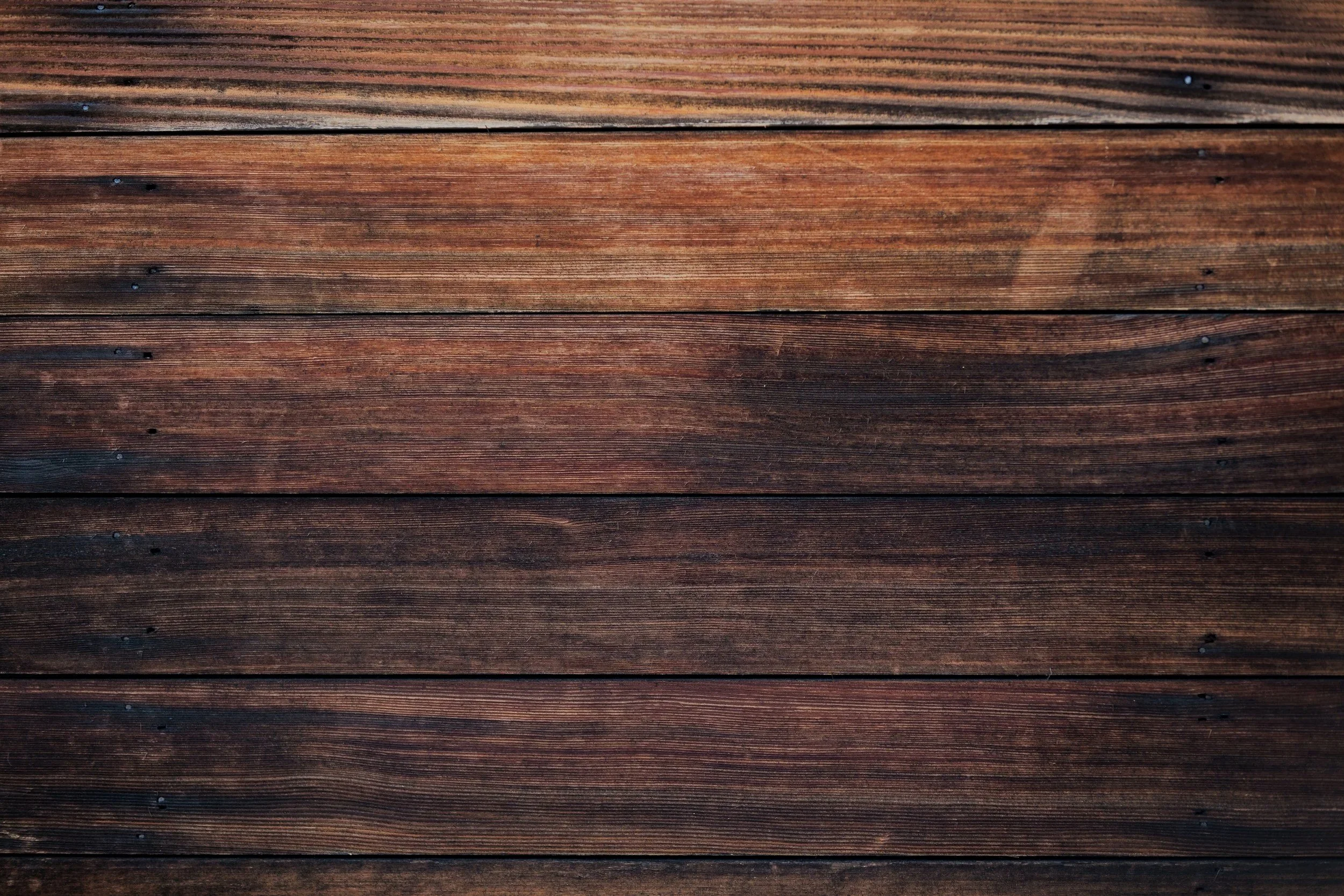 Close-up of a wooden surface with horizontal planks showing natural wood grain and knots.